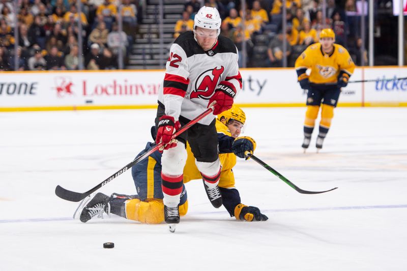 Feb 13, 2024; Nashville, Tennessee, USA;  Nashville Predators left wing Mark Jankowski (17) and New Jersey Devils center Curtis Lazar (42) fight for the puck during the second period at Bridgestone Arena. Mandatory Credit: Steve Roberts-USA TODAY Sports