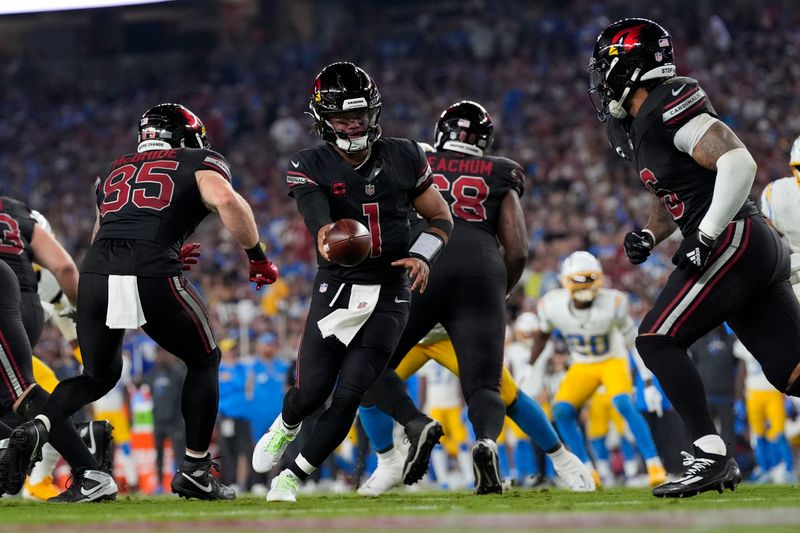 Arizona Cardinals quarterback Kyler Murray (1) hands the ball off during the second half of an NFL football game against the Los Angeles Chargers, Monday, Oct. 21, 2024, in Glendale Ariz. (AP Photo/Ross D. Franklin)