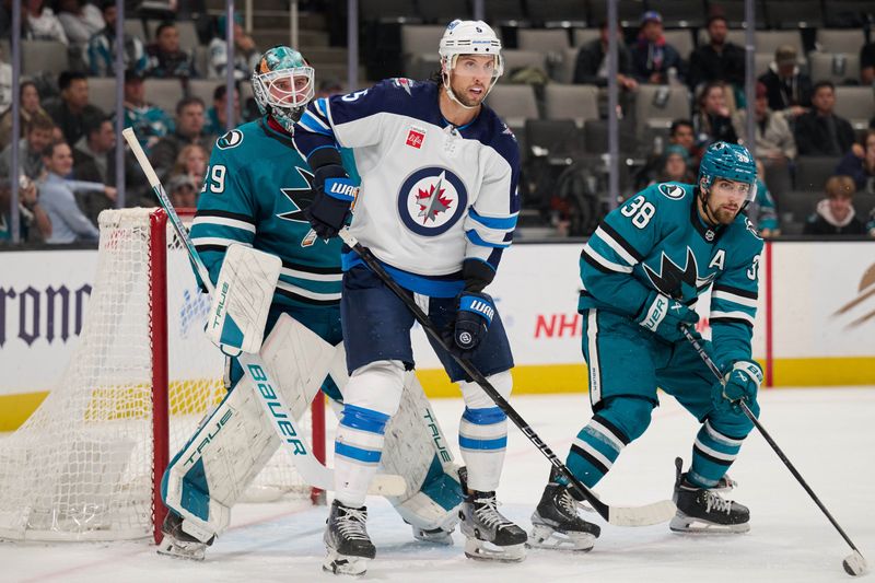 Dec 12, 2023; San Jose, California, USA; Winnipeg Jets defenseman Brenden Dillon (5) stands in the goal crease against San Jose Sharks goaltender Mackenzie Blackwood (29) and defenseman Mario Ferraro (38) during the third period at SAP Center at San Jose. Mandatory Credit: Robert Edwards-USA TODAY Sports