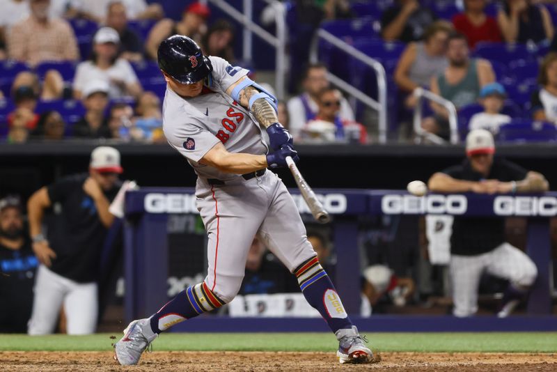 Jul 4, 2024; Miami, Florida, USA; Boston Red Sox left fielder Tyler O'Neill (17) hits an RBI double against the Miami Marlins during the twelfth inning at loanDepot Park. Mandatory Credit: Sam Navarro-USA TODAY Sports