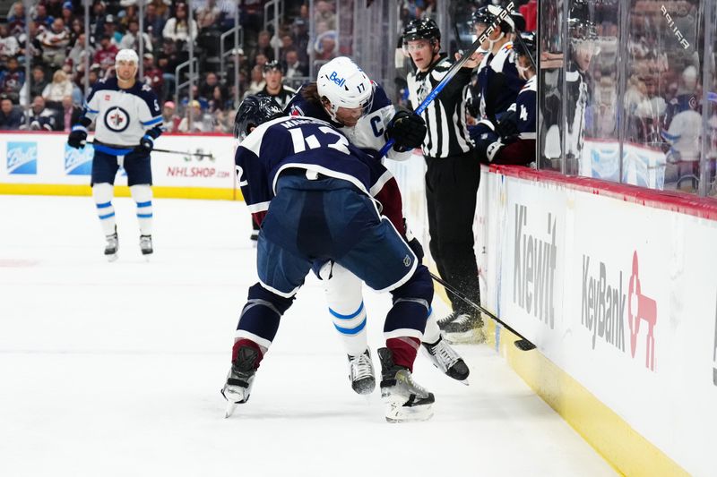 Dec 7, 2023; Denver, Colorado, USA; Colorado Avalanche defenseman Josh Manson (42) collides into Winnipeg Jets center Adam Lowry (17) in the third period at Ball Arena. Mandatory Credit: Ron Chenoy-USA TODAY Sports