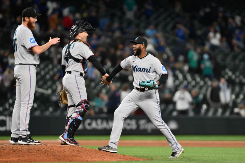 Jun 14, 2023; Seattle, Washington, USA; Miami Marlins relief pitcher A.J. Puk (35) and catcher Nick Fortes (4) and left fielder Bryan De La Cruz (14) celebrate defeating the Seattle Mariners at T-Mobile Park. Mandatory Credit: Steven Bisig-USA TODAY Sports