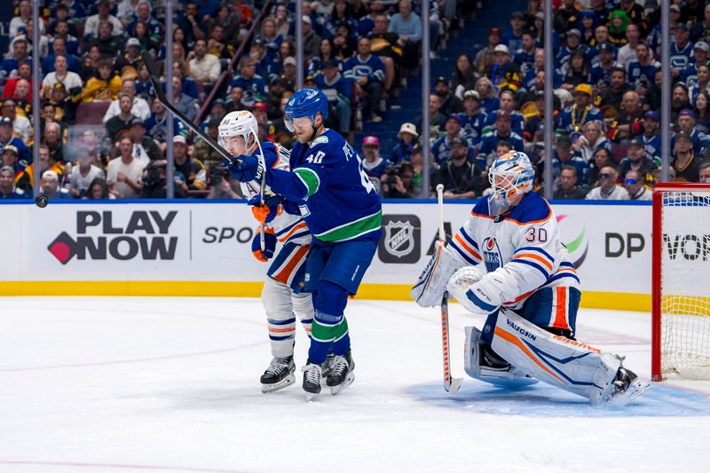 May 16, 2024; Vancouver, British Columbia, CAN; Edmonton Oilers goalie Calvin Pickard (30) watches as Vancouver Canucks forward Elias Pettersson (40) battles with forward Ryan Nugent Hopkins (93) during the third period in game five of the second round of the 2024 Stanley Cup Playoffs at Rogers Arena. Mandatory Credit: Bob Frid-USA TODAY Sports