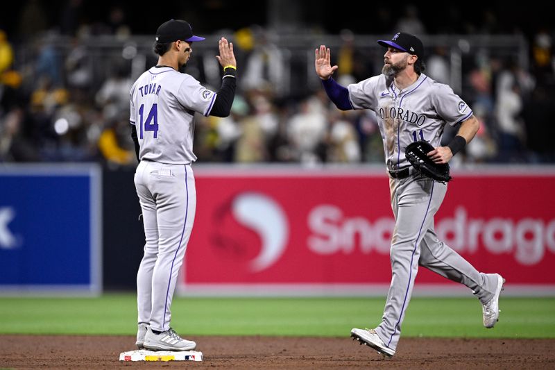 May 13, 2024; San Diego, California, USA; Colorado Rockies shortstop Ezequiel Tovar (14) and right fielder Jake Cave (11) celebrate on the field after defeating the San Diego Padres at Petco Park. Mandatory Credit: Orlando Ramirez-USA TODAY Sports