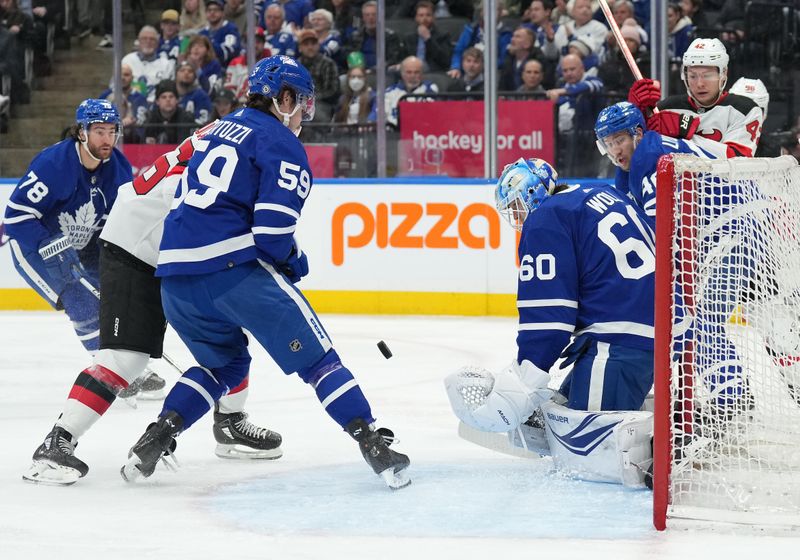 Mar 26, 2024; Toronto, Ontario, CAN; Toronto Maple Leafs left wing Tyler Bertuzzi (59) battles for the puck in front of  goaltender Joseph Woll (60) against the New Jersey Devils during the second period at Scotiabank Arena. Mandatory Credit: Nick Turchiaro-USA TODAY Sports