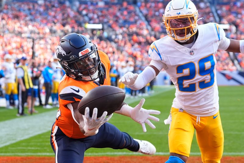Denver Broncos wide receiver Courtland Sutton (14) catches a 15-yard touchdown pass against Los Angeles Chargers cornerback Tarheeb Still (29) during the second half of an NFL football game, Sunday, Oct. 13, 2024, in Denver. (AP Photo/David Zalubowski)