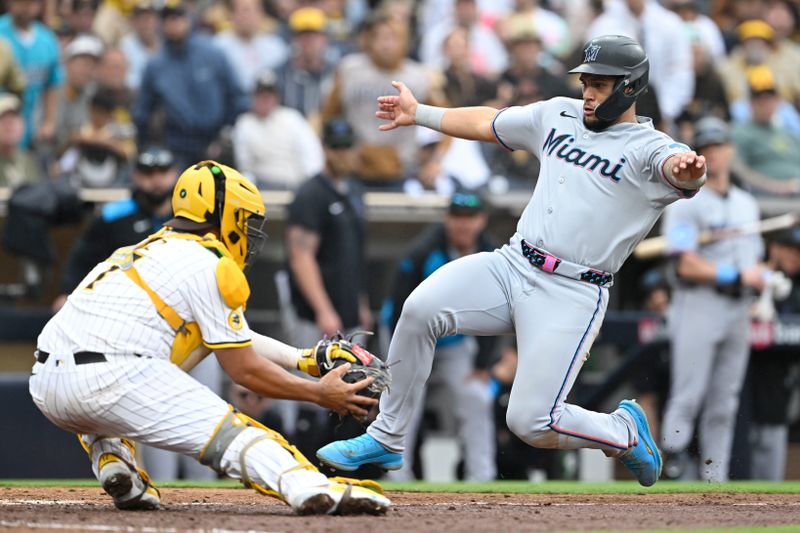May 28, 2025; San Diego, California, USA; Miami Marlins catcher Agustin Ramirez (50) is tagged out at the plate by San Diego Padres catcher Elias Diaz (17) during the eighth inning at Petco Park.  Mandatory Credit: Denis Poroy-Imagn Images