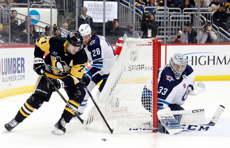 Jan 13, 2023; Pittsburgh, Pennsylvania, USA; Pittsburgh Penguins center Evgeni Malkin (71) skates with the puck around the net as Winnipeg Jets center Kevin Stenlund (28) and goaltender David Rittich (33) defend during the third period at PPG Paints Arena. Mandatory Credit: Charles LeClaire-USA TODAY Sports