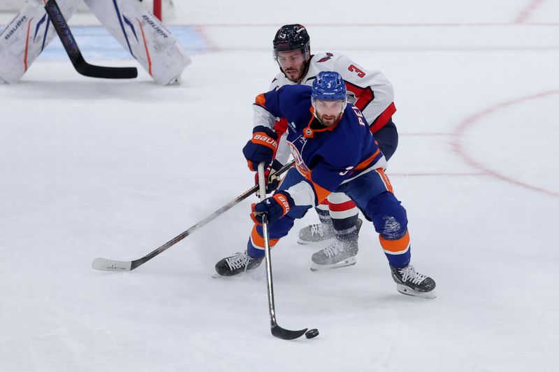 Oct 11, 2025; Elmont, New York, USA; New York Islanders defenseman Adam Pelech (3) plays the puck against Washington Capitals defenseman Matt Roy (3) during the first period at UBS Arena. Mandatory Credit: Brad Penner-Imagn Images