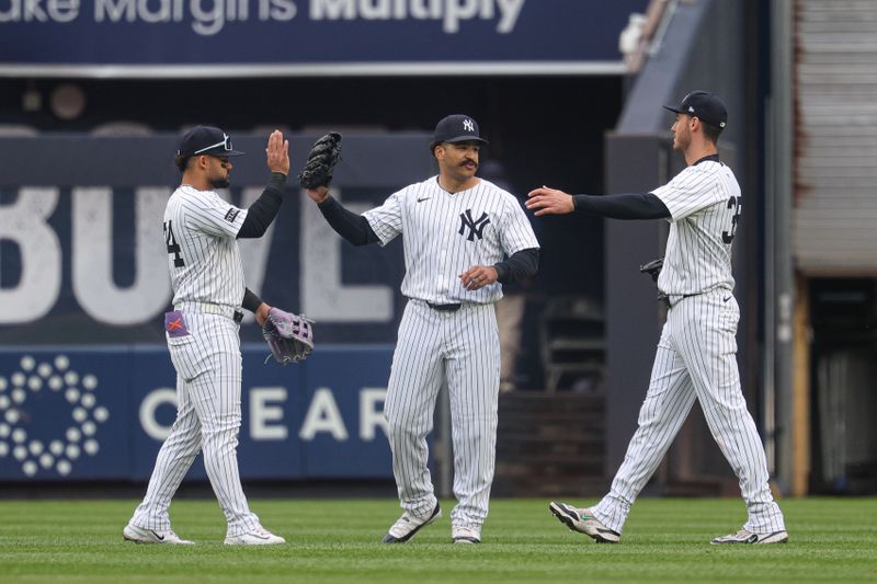 May 22, 2025; Bronx, New York, USA; New York Yankees left fielder Jasson Dominguez (24) celebrates with center fielder Trent Grisham (12) and right fielder Cody Bellinger (35) after defeating the Texas Rangers at Yankee Stadium. Mandatory Credit: Vincent Carchietta-Imagn Images