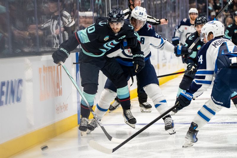 Oct 24, 2024; Seattle, Washington, USA;  Winnipeg Jets forward Mark Scheifele (55) checks Seattle Kraken forward Matty Beniers (10) into the boards during the third period at Climate Pledge Arena. Mandatory Credit: Stephen Brashear-Imagn Images