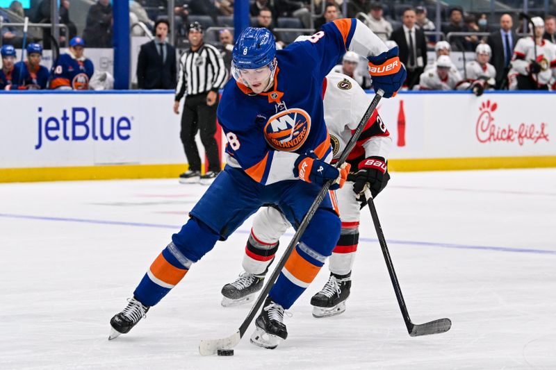 Jan 14, 2025; Elmont, New York, USA;  New York Islanders defenseman Noah Dobson (8) skates with the puck against the Ottawa Senators during the second period at UBS Arena. Mandatory Credit: Dennis Schneidler-Imagn Images