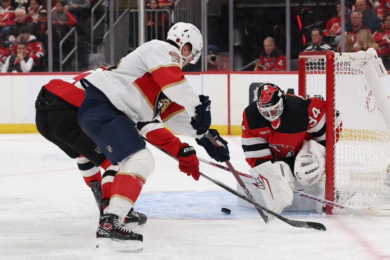 Oct 16, 2025; Newark, New Jersey, USA; New Jersey Devils goaltender Jake Allen (34) makes a save against the Florida Panthers during the third period at Prudential Center. Mandatory Credit: Ed Mulholland-Imagn Images