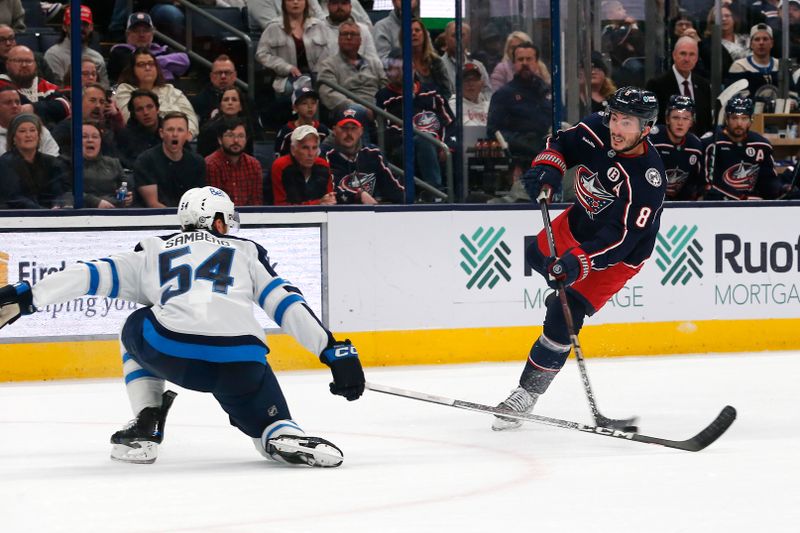 Nov 1, 2024; Columbus, Ohio, USA; Columbus Blue Jackets defenseman Zach Werenski (8) wrists a shot on goal over the stick of Winnipeg Jets defenseman Dylan Samberg (54) during the second period at Nationwide Arena. Mandatory Credit: Russell LaBounty-Imagn Images