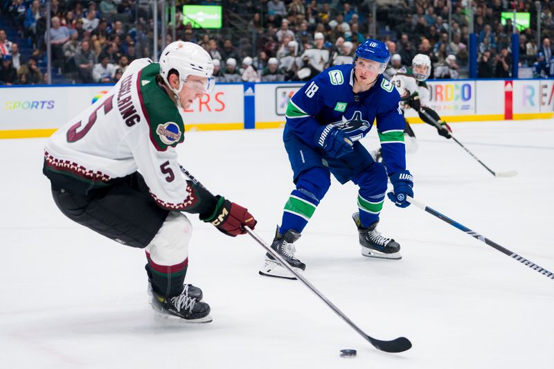 Jan 18, 2024; Vancouver, British Columbia, CAN; Vancouver Canucks forward Sam Lafferty (18) defends against Arizona Coyotes defenseman Michael Kesselring (5) in the third period at Rogers Arena. Vancouver won 2-1. Mandatory Credit: Bob Frid-USA TODAY Sports