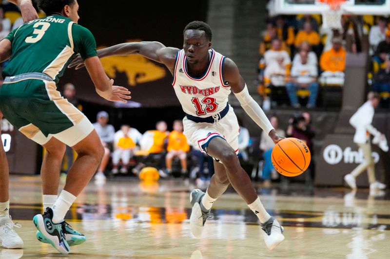 Jan 27, 2024; Laramie, Wyoming, USA; Cowboys guard Akuel Kot (13) drives against Colorado State Rams guard Josiah Strong (3) during the first half at Arena-Auditorium. Mandatory Credit: Troy Babbitt-USA TODAY Sports