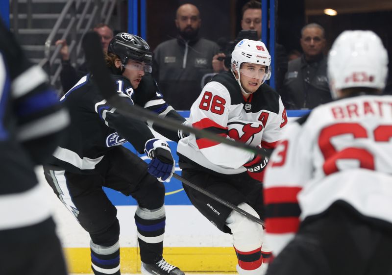 Oct 11, 2025; Tampa, Florida, USA; New Jersey Devils center Jack Hughes (86) skates with the puck as Tampa Bay Lightning center Conor Geekie (14) defends during the second period at Benchmark International Arena. Mandatory Credit: Kim Klement Neitzel-Imagn Images