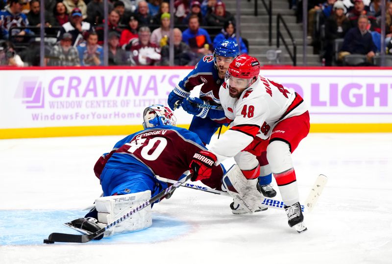 Nov 9, 2024; Denver, Colorado, USA; Carolina Hurricanes left wing Jordan Martinook (48) scores around Colorado Avalanche goaltender Alexandar Georgiev (40) in the third period at Ball Arena. Mandatory Credit: Ron Chenoy-Imagn Images