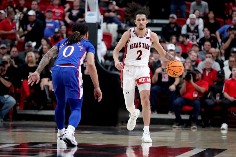 Jan 3, 2023; Lubbock, Texas, USA;  Texas Tech Red Raiders guard Pop Issacs (2) brings the ball up court against Kansas Jayhawks guard Bobby Pettiford Jr (0) in the first half at United Supermarkets Arena. Mandatory Credit: Michael C. Johnson-USA TODAY Sports