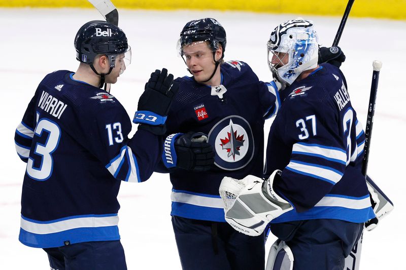 Apr 21, 2024; Winnipeg, Manitoba, CAN; Winnipeg Jets center Gabriel Vilardi (13), center Vladislav Namestnikov (7) and  goaltender Connor Hellebuyck (37) celebrate their victory over the Colorado Avalanche in game one of the first round of the 2024 Stanley Cup Playoffs at Canada Life Centre. Mandatory Credit: James Carey Lauder-USA TODAY Sports