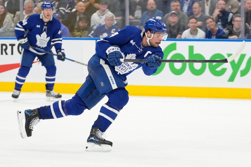 Oct 21, 2024; Toronto, Ontario, CAN; Toronto Maple Leafs forward Auston Matthews (34) shoots the puck against the Tampa Bay Lightning during the third period at Scotiabank Arena. Mandatory Credit: John E. Sokolowski-Imagn Images