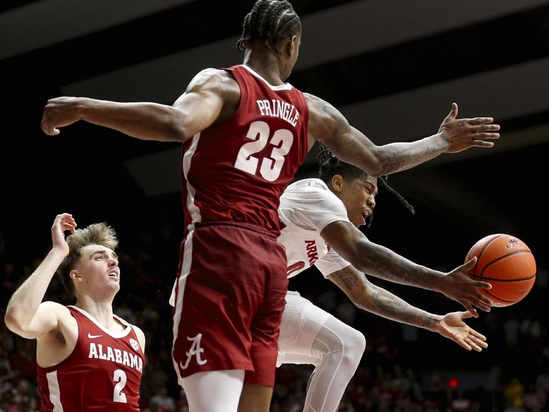 Mar 9, 2024; Tuscaloosa, Alabama, USA;  Arkansas guard Khalif Battle (0) makes a pass as his drive to the basket is defined by Alabama forward Nick Pringle (23) at Coleman Coliseum. Alabama came from behind to win on overtime 92-88. Mandatory Credit: Gary Cosby Jr.-USA TODAY Sports