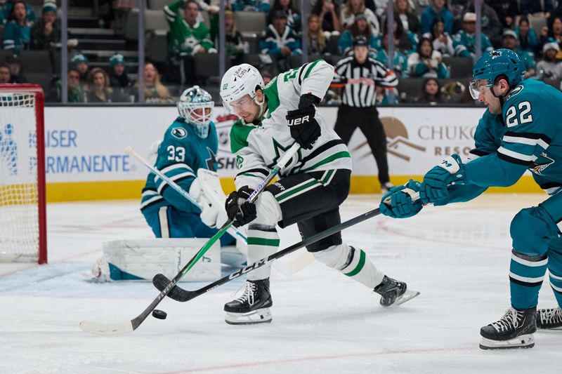 Dec 18, 2025; San Jose, California, USA; Dallas Stars center Mavrik Bourque (22) plays the puck against San Jose Sharks goaltender Alex Nedeljkovic (33) and defenseman Vincent Iorio (22) during the first period at SAP Center at San Jose. Mandatory Credit: Robert Edwards-Imagn Images