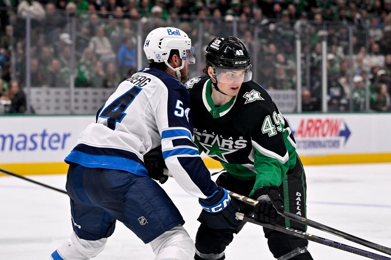 Feb 2, 2026; Dallas, Texas, USA; Winnipeg Jets defenseman Dylan Samberg (54) checks Dallas Stars center Justin Hryckowian (49) during the second period at the American Airlines Center. Mandatory Credit: Jerome Miron-Imagn Images