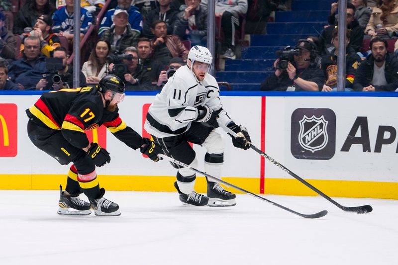 Feb 29, 2024; Vancouver, British Columbia, CAN; Los Angeles Kings forward Anze Kopitar (11) drives past Vancouver Canucks defenseman Filip Hronek (17) in the second period at Rogers Arena. Mandatory Credit: Bob Frid-USA TODAY Sports