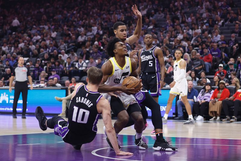 SACRAMENTO, CALIFORNIA - MARCH 31: Collin Sexton #2 of the Utah Jazz drives to the basket against Domantas Sabonis #10 and Keegan Murray #13 of the Sacramento Kings in the first quarter at Golden 1 Center on March 31, 2024 in Sacramento, California. NOTE TO USER: User expressly acknowledges and agrees that, by downloading and or using this photograph, User is consenting to the terms and conditions of the Getty Images License Agreement. (Photo by Lachlan Cunningham/Getty Images)