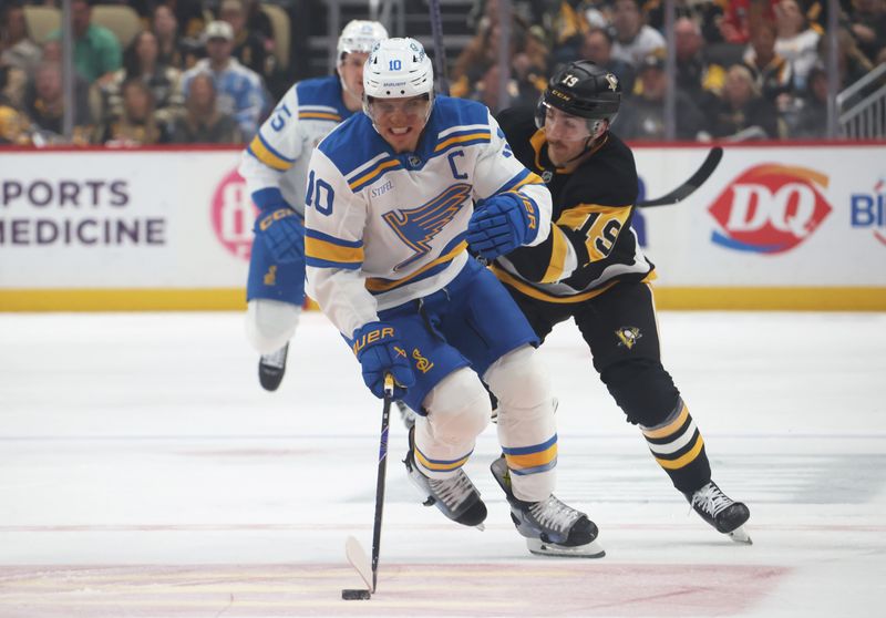 Oct 27, 2025; Pittsburgh, Pennsylvania, USA;  St. Louis Blues center Brayden Schenn (10) skates with the puck ahead of Pittsburgh Penguins center Connor Dewar (19) during the first period at PPG Paints Arena. Mandatory Credit: Charles LeClaire-Imagn Images