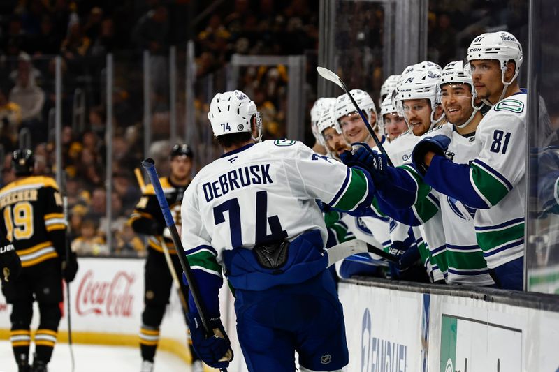 Nov 26, 2024; Boston, Massachusetts, USA; Vancouver Canucks left wing Jake DeBrusk (74) is congratulated by smiling teammates after scoring on his former team, the Boston Bruins during the second period at TD Garden. Mandatory Credit: Winslow Townson-Imagn Images