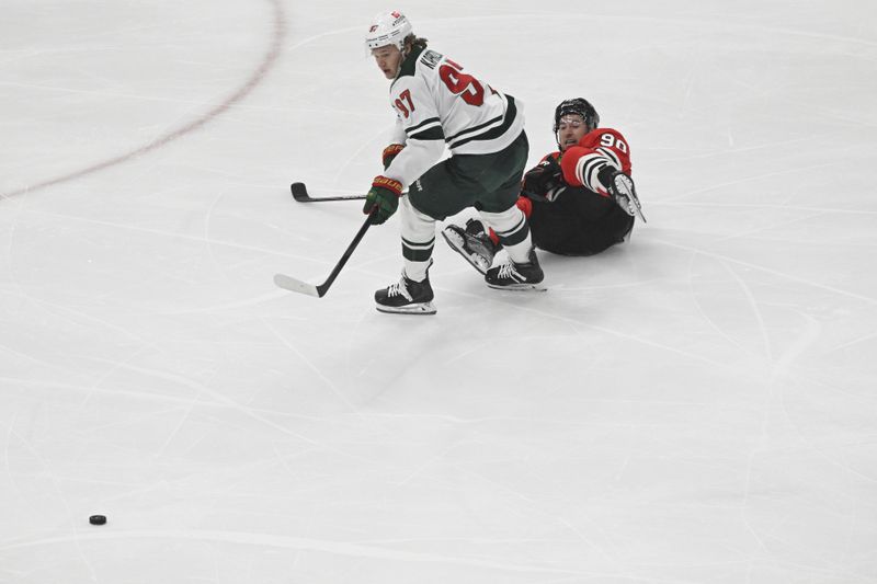 Apr 7, 2024; Chicago, Illinois, USA;  Chicago Blackhawks center Tyler Johnson (90) and Minnesota Wild left wing Kirill Kaprizov (97) chase the puck during the first period at the United Center. Mandatory Credit: Matt Marton-USA TODAY Sports