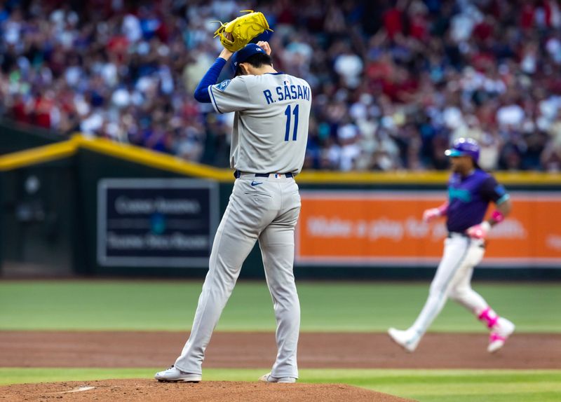 May 9, 2025; Phoenix, Arizona, USA; Los Angeles Dodgers pitcher Roki Sasaki reacts after giving up a home run to Arizona Diamondbacks infielder Ketel Marte in the first inning at Chase Field. Mandatory Credit: Mark J. Rebilas-Imagn Images