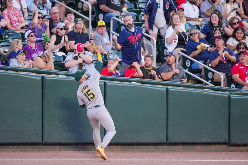 Jun 13, 2024; Minneapolis, Minnesota, USA; Oakland Athletics outfielder Seth Brown (15) fields a fly ball against the Minnesota Twins in the fourth inning at Target Field. Mandatory Credit: Brad Rempel-USA TODAY Sports