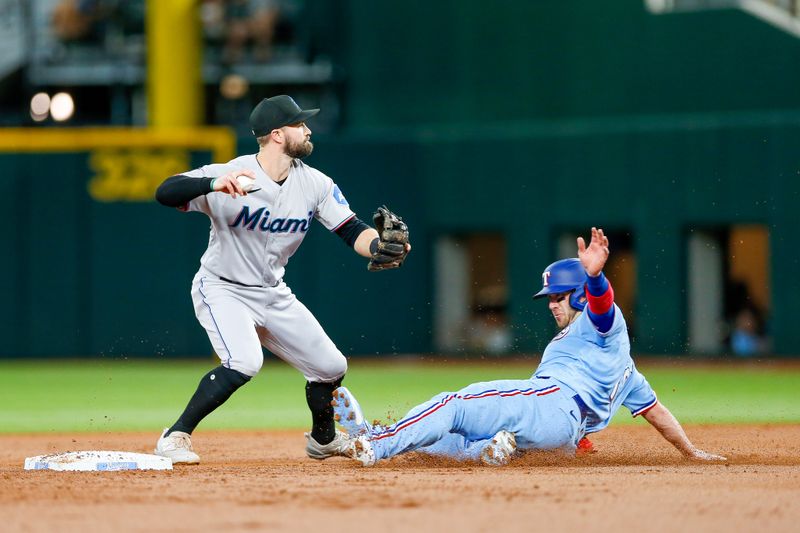 Aug 6, 2023; Arlington, Texas, USA; Miami Marlins shortstop Jon Berti (5) attempts to turn a double play with Texas Rangers catcher Mitch Garver (18) sliding into second base during the second inning at Globe Life Field. Mandatory Credit: Andrew Dieb-USA TODAY Sports