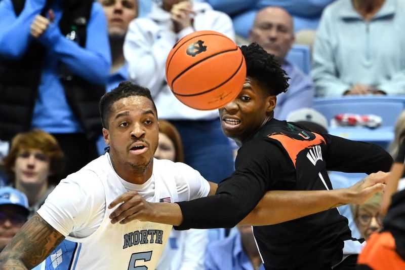 Feb 13, 2023; Chapel Hill, North Carolina, USA; North Carolina Tar Heels forward Armando Bacot (5) and Miami (Fl) Hurricanes forward Anthony Walker (1) fight for the ball in the first half at Dean E. Smith Center. Mandatory Credit: Bob Donnan-USA TODAY Sports