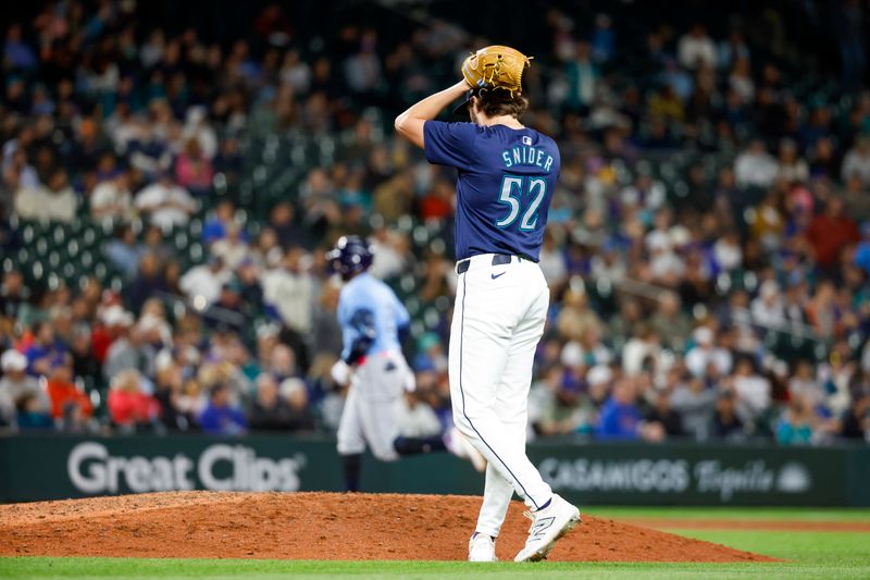 Aug 27, 2024; Seattle, Washington, USA; Seattle Mariners relief pitcher Collin Snider (52) reacts after surrendering a solo home run to Tampa Bay Rays first baseman Yandy Diaz (2, background) during the eighth inning at T-Mobile Park. Mandatory Credit: Joe Nicholson-USA TODAY Sports