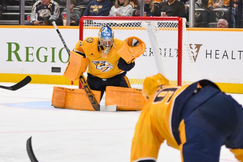 Oct 23, 2025; Nashville, Tennessee, USA;  Nashville Predators goaltender Juuse Saros (74) makes a glove save against the Vancouver Canucks during the second period at Bridgestone Arena. Mandatory Credit: Steve Roberts-Imagn Images