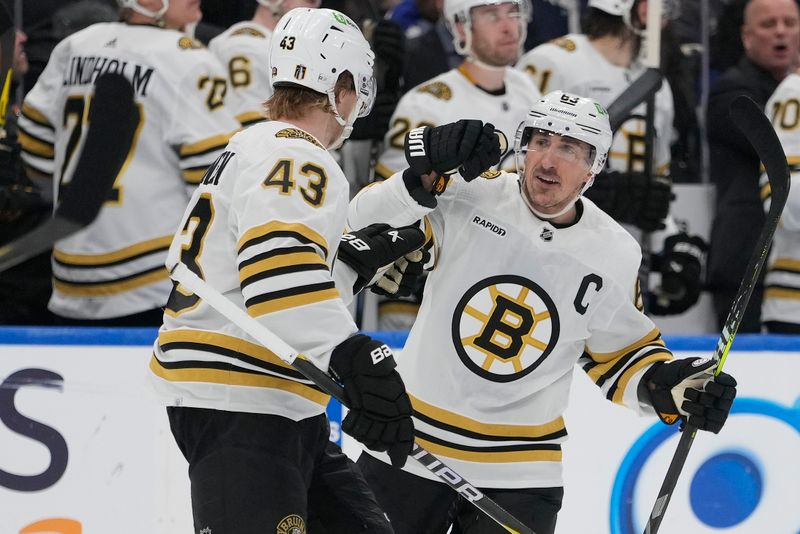 Apr 24, 2024; Toronto, Ontario, CAN; Boston Bruins forward Brad Marchand (63) celebrates his first goal of game against the Toronto Maple Leafs with Boston Bruins forward Danton Heinen (43) during the third period of game three of the first round of the 2024 Stanley Cup Playoffs at Scotiabank Arena. Mandatory Credit: John E. Sokolowski-USA TODAY Sports