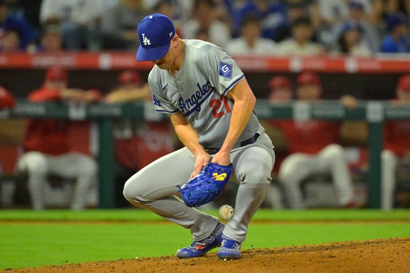 Sep 3, 2024; Anaheim, California, USA;  Los Angeles Dodgers starting pitcher Walker Buehler (21) is able to control the ball and throw Los Angeles Angels first baseman Nolan Schanuel (18) out at first in the fifth inning at Angel Stadium. Mandatory Credit: Jayne Kamin-Oncea-Imagn Images