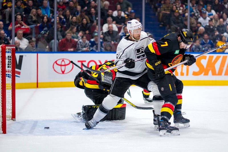 Mar 25, 2024; Vancouver, British Columbia, CAN; Los Angeles Kings forward Trevor Lewis (61) battles with Vancouver Canucks defenseman Carson Soucy (7) as the shot from forward Blake Lizotte (not pictured) beats goalie Casey DeSmith (29) in the second period at Rogers Arena. Mandatory Credit: Bob Frid-USA TODAY Sports