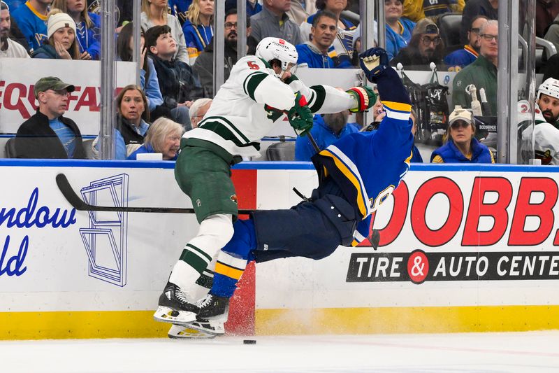 Nov 19, 2024; St. Louis, Missouri, USA;  Minnesota Wild defenseman Jake Middleton (5) checks St. Louis Blues center Alexandre Texier (9) during the second period at Enterprise Center. Mandatory Credit: Jeff Curry-Imagn Images