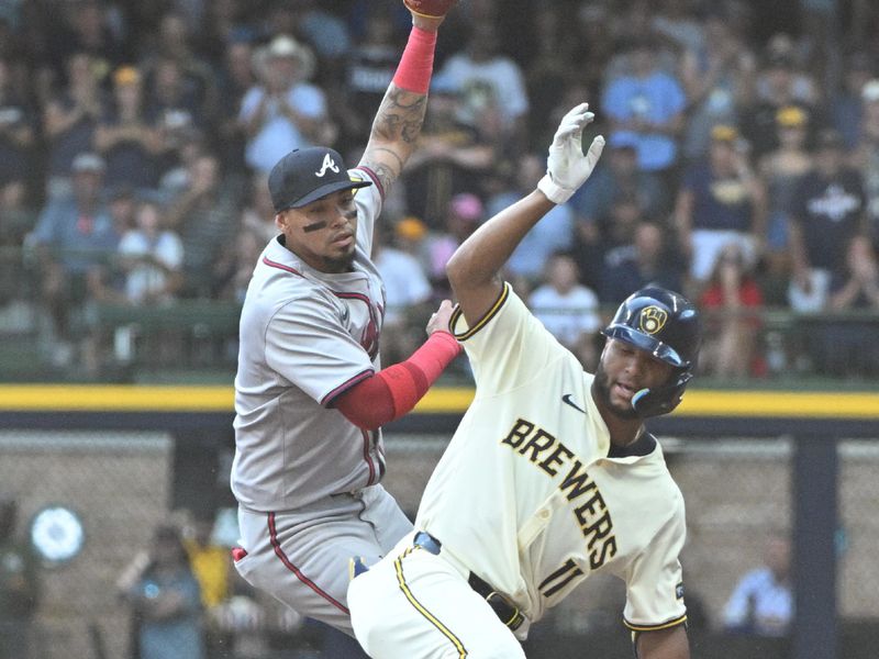 Jul 31, 2024; Milwaukee, Wisconsin, USA; Milwaukee Brewers outfielder Jackson Chourio (11) stretches a hit into a double against Atlanta Braves shortstop Orlando Arcia (11) in the second inning at American Family Field. Mandatory Credit: Michael McLoone-USA TODAY Sports