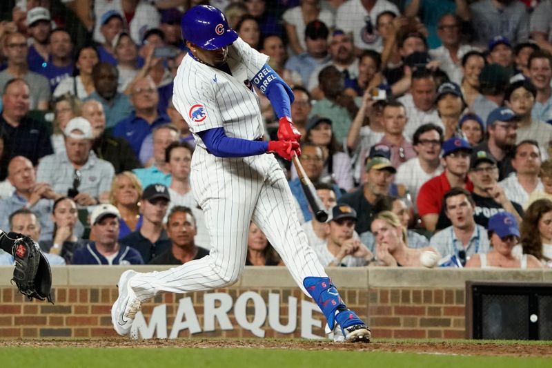 Jun 18, 2024; Chicago, Illinois, USA; Chicago Cubs third base Christopher Morel (5) hits a single against the San Francisco Giants during the eighth inning at Wrigley Field. Mandatory Credit: David Banks-USA TODAY Sports