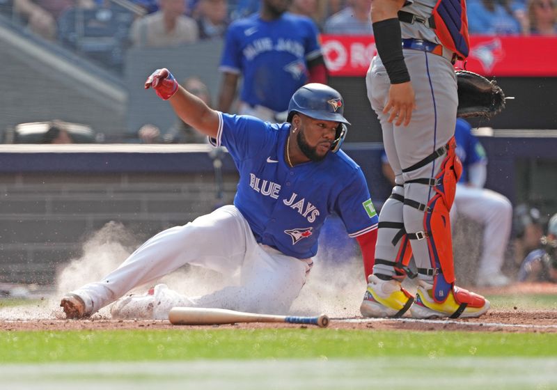 Sep 11, 2024; Toronto, Ontario, CAN; Toronto Blue Jays first baseman Vladimir Guerrero Jr. (27) slides into home plate scoring a run against the New York Mets during the fourth inning at Rogers Centre. Mandatory Credit: Nick Turchiaro-Imagn Images