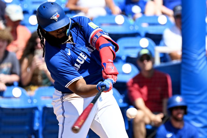 Mar 15, 2024; Dunedin, Florida, USA; Toronto Blue Jays first baseman Vladimir Guerrero Jr. (27) drives in two runs with a single in the first inning of a spring training game against the Detroit Tigers at TD Ballpark. Mandatory Credit: Jonathan Dyer-USA TODAY Sports