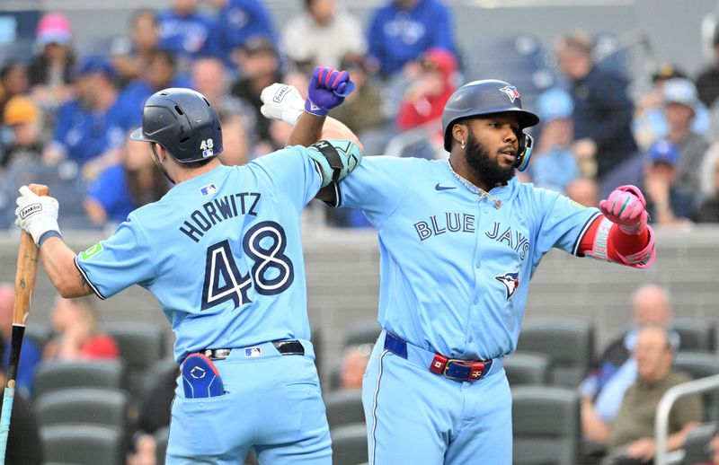 Aug 19, 2024; Toronto, Ontario, CAN; Toronto Blue Jays designated hitter Vladimir Guerrero Jr. (27) celebrates with first baseman Spencer Horwitz (48) after hitting a solo home run against the Cincinnati Reds in the first inning at Rogers Centre. Mandatory Credit: Dan Hamilton-USA TODAY Sports