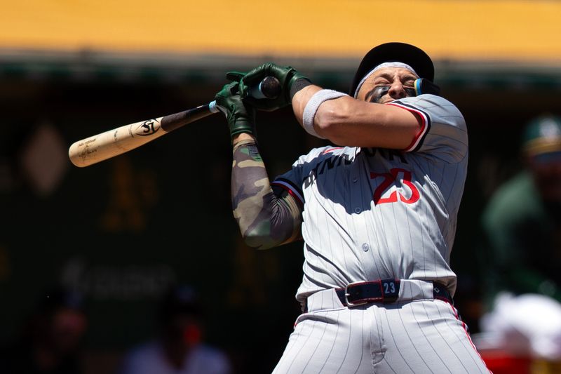 Jun 22, 2024; Oakland, California, USA; Minnesota Twins designated hitter Royce Lewis (23) ducks away from a high and tight pitch from Oakland Athletics pitcher Osvaldo Bido during the third inning at Oakland-Alameda County Coliseum. Mandatory Credit: D. Ross Cameron-USA TODAY Sports