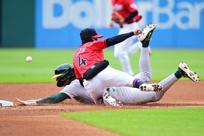 Apr 21, 2024; Cleveland, Ohio, USA; Oakland Athletics second baseman Zack Gelof (20) steals second as Cleveland Guardians shortstop Brayan Rocchio (4) misses the throw during the second inning at Progressive Field. Mandatory Credit: Ken Blaze-USA TODAY Sports